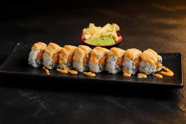 Topped sushi roll with sauce